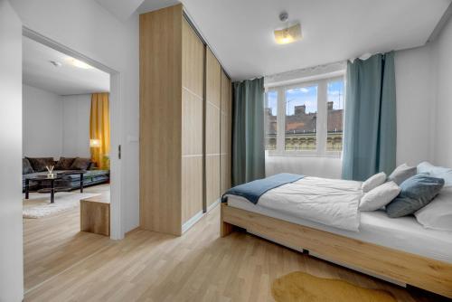Un dormitorio con una cama y una ventana grande. en REVON Art-deco Apartment Laurinska, Parking options, en Bratislava