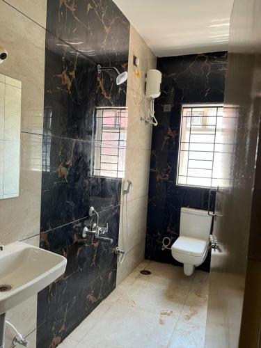 ein Badezimmer mit Toilette und Waschbecken in der Unterkunft 4C NRI Residency in Tirupati