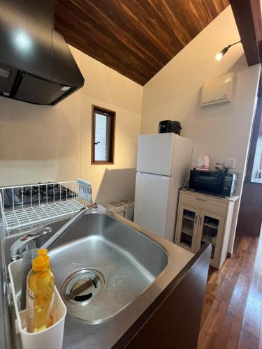 a kitchen with a sink and a refrigerator at Karisome in Motobu