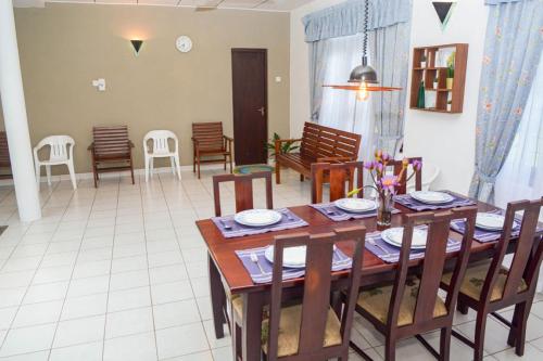 a dining room with a wooden table and chairs at Villa for leisure and work at Kalutara suburbs in Bandaragama