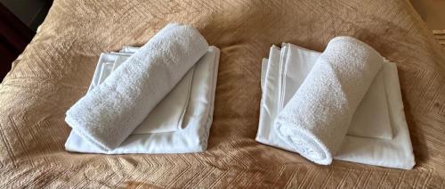 two white towels sitting on top of a bed at Villa Utsikten Romsdalshorn in Åndalsnes
