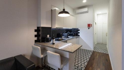 a kitchen with a counter and some chairs in it at Boavista 1774 by LovelyStay in Porto