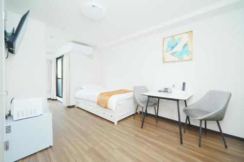 a bedroom with a bed and a table and chairs at 東京リリアルホテル201 in Tokyo