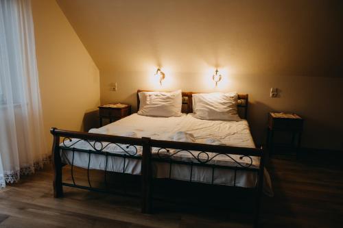 a bedroom with a bed with two lamps on it at Apartament Róża in Solec-Zdrój