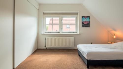 a bedroom with a bed and a window at De IJsvogel in Schoorl