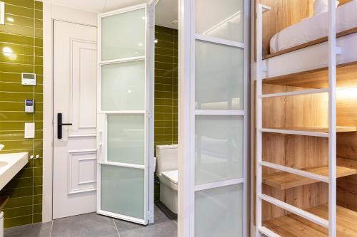 バルセロナにあるWeflating Boutique Hostelのガラス棚とトイレ付きのウォークインクローゼット
