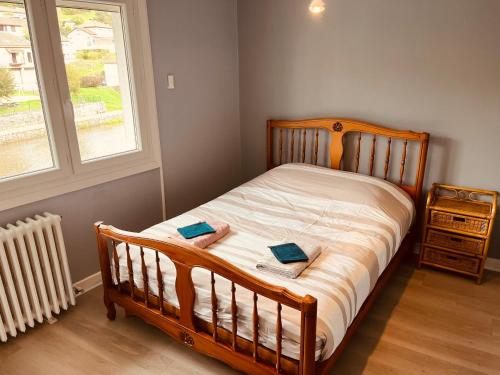 - une chambre avec un lit en bois et 2 certificats dans l'établissement Maison sur les bords de Cere, Laroquebrou, balcon terrasse 3 chambres, à Laroquebrou