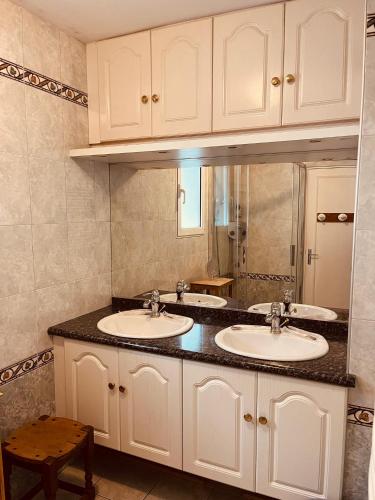 une salle de bain avec deux lavabos et un miroir dans l'établissement Maison sur les bords de Cere, Laroquebrou, balcon terrasse 3 chambres, à Laroquebrou