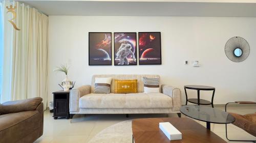 a living room with a couch and paintings on the wall at Modern Urban Studio - Stylish Haven in Abu Dhabi