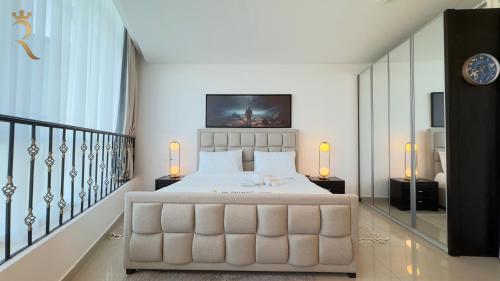 a bedroom with a large white bed and a staircase at Modern Urban Studio - Stylish Haven in Abu Dhabi