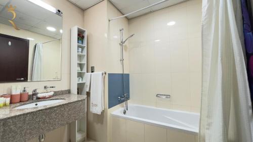 a bathroom with a tub and a sink and a shower at Galaxy Studio Apartment on Al Reem Island - Cozy Stay Near Reem Mall & Al Maryah Island in Abu Dhabi