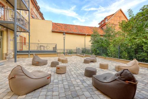 a group of chairs and seats in a courtyard at Ferienwohnungen Steinweg 61 in Quedlinburg