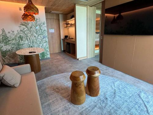 a living room with two wooden stools in a room at Novotel Recife Marina in Recife
