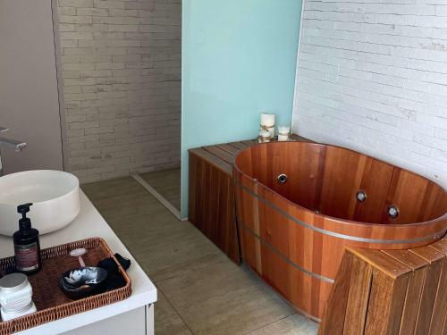 a bathroom with a wooden tub and a sink at Novotel Recife Marina in Recife