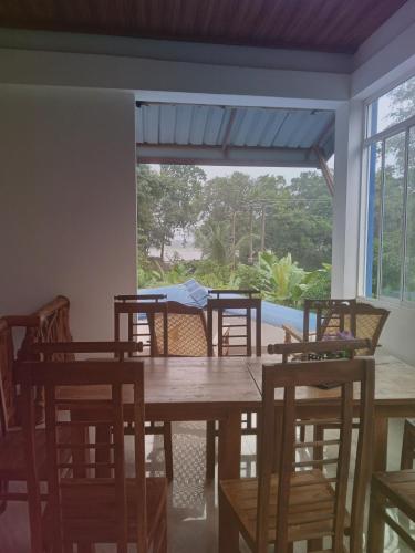 a dining room with a table and chairs and a window at Bungalow Resort - Sigiriya in Sigiriya