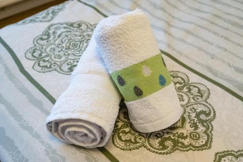a roll of white sock sitting on a bed at Central Apartments - Green in Bacău