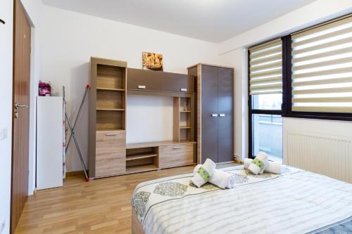 a bedroom with a large bed and a large window at Central Apartments - Green in Bacău