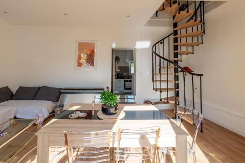 un salon avec une table et un escalier en colimaçon dans l'établissement Accords Parfaits Famille, à Villeurbanne