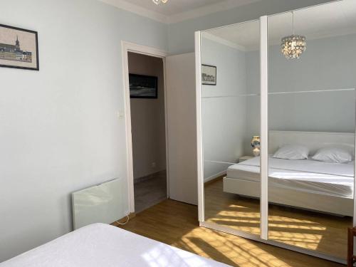 - une chambre blanche avec un miroir et un lit dans l'établissement Maison 2 pers avec jardin clos, terrasse à TREBEURDEN - Réf 671, à Trébeurden