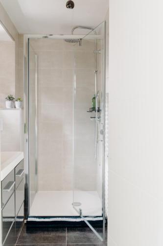 a glass shower with a chair in a bathroom at La Suite D'Hélène - Appartement - 50m2 entre Genève et Chamonix - Parking Privé - Wifi in Scionzier