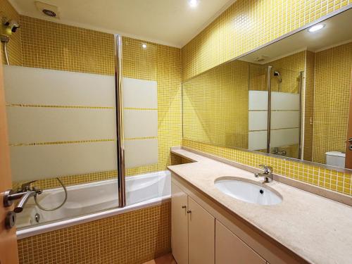 een badkamer met een wastafel, een bad en een spiegel bij 4D Terrace A - Casas & Papeis in Armação de Pêra