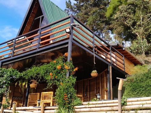 a log cabin with a green roof at Cabaña Starka & Jacuzzi in Marinilla