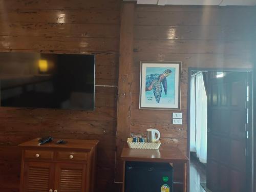 a room with a wooden wall with a picture of a bird at Nangyuan Island Dive Resort in Koh Tao