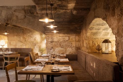 a restaurant with tables and chairs in a room at Masseria Donna Menga - The Leading Hotels of the World in Torre Lapillo