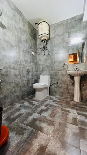 a bathroom with a toilet and a sink at The Sana Luxury Stay, Manali in Manāli