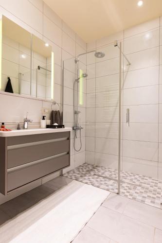 a bathroom with a shower with a sink and a glass shower stall at Dreamland Golf Hotel Baku in Baku