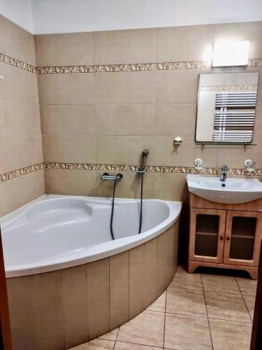 a bathroom with a tub and a sink at HOTEL RESTAURACJA WESOŁA in Lisia Góra
