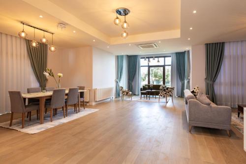 a dining room and living room with a table and chairs at Dreamland Golf Hotel Baku in Baku