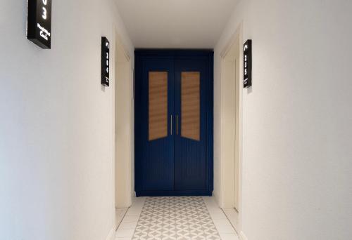 a hallway with a blue door in a building at The North Wind in Ayvalık