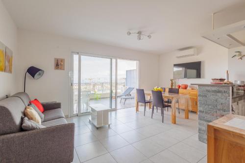 un salon avec un canapé et une table dans l'établissement La Paolina - Appt 4p avec vue sur golfe de Calvi, à LʼÎle-Rousse