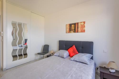 - une chambre avec un lit et un oreiller rouge dans l'établissement La Paolina - Appt 4p avec vue sur golfe de Calvi, à LʼÎle-Rousse