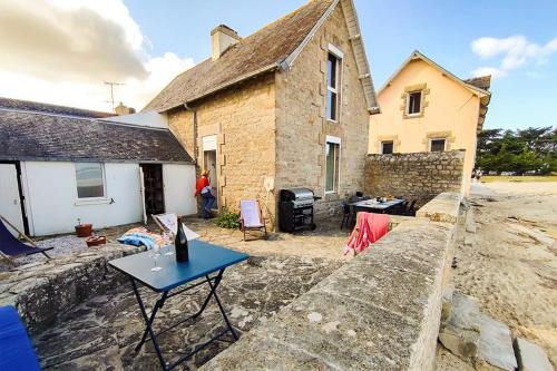 a stone house with a table in front of it at La Maison de la Plage - vue mer, 5' du port, 6 personnes in Île-Tudy