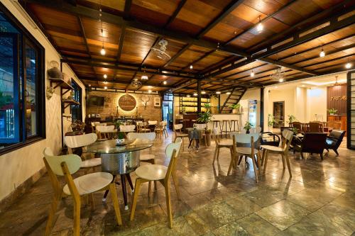 a restaurant with tables and chairs in a room at The Muse House in Hoi An