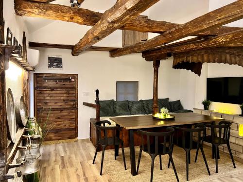 una sala da pranzo con tavolo, sedie e divano di Туйковата къща The Tuikov House a Teteven