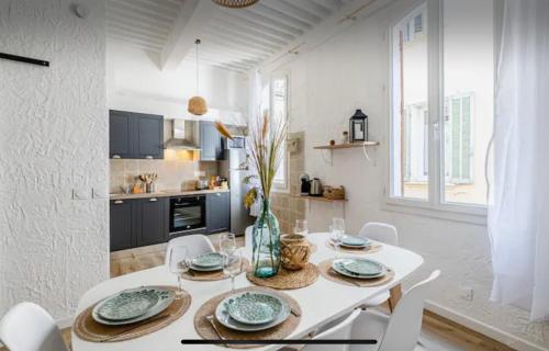 une salle à manger blanche avec une table et des chaises blanches dans l'établissement Iris la ciotat, à La Ciotat