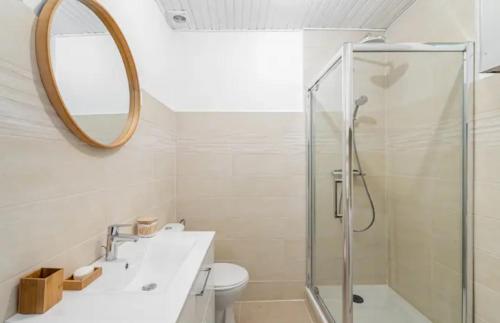 une salle de bain avec une douche, un lavabo et un miroir dans l'établissement Iris la ciotat, à La Ciotat