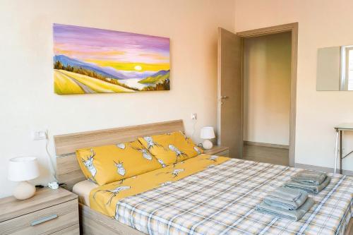 Un dormitorio con una cama amarilla y una pintura en la pared en Large Suite Home Milan - Duomo, en Milán
