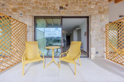 two yellow chairs and a table on a balcony at Relais Ca Bago' -adults only in Costermano sul Garda