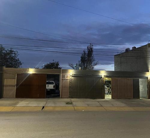 a house with a garage at night with lights at Rufina Departamentos in San Juan