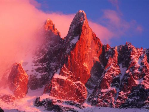 a mountain covered in snow with a red sky at Apartment Lognan 1 - A Chamonix Mont Blanc Haven in Chamonix-Mont-Blanc
