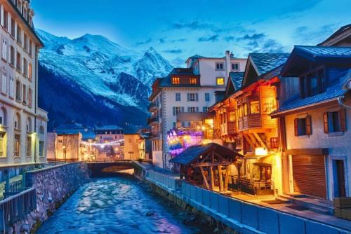 a river in a city with mountains in the background at Apartment Lognan 1 - A Chamonix Mont Blanc Haven in Chamonix-Mont-Blanc