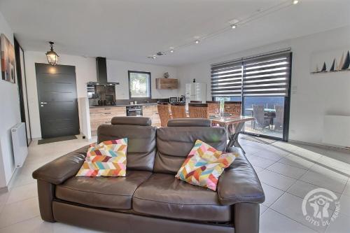 un salon avec un canapé en cuir et une cuisine dans l'établissement Villa armor azur, à Erquy