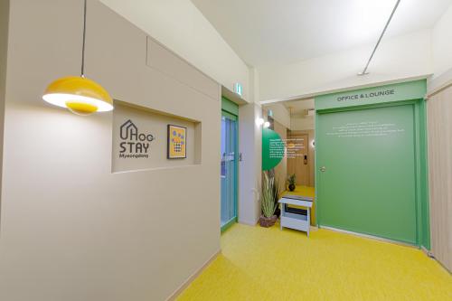 an office hallway with a green door and a sign at Uhoostay Myeongdong Guesthouse in Seoul