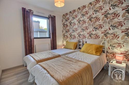 Un dormitorio con dos camas y una ventana. en Villa armor azur, en Erquy