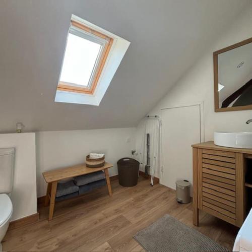 La salle de bains est pourvue d'un lavabo, d'une table et d'une fenêtre. dans l'établissement Appartement 2 personnes, à Lestrem