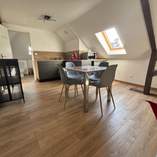 une cuisine et une salle à manger avec une table et des chaises dans l'établissement Appartement 2 personnes, à Lestrem